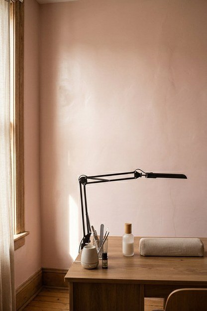 A soft blush accent wall with a satin sheen behind a nail station