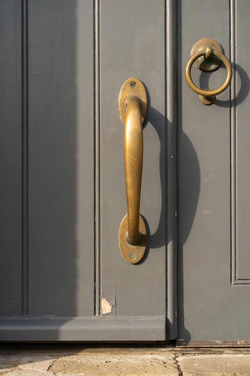 Warm brass handle and knocker on a charcoal front door