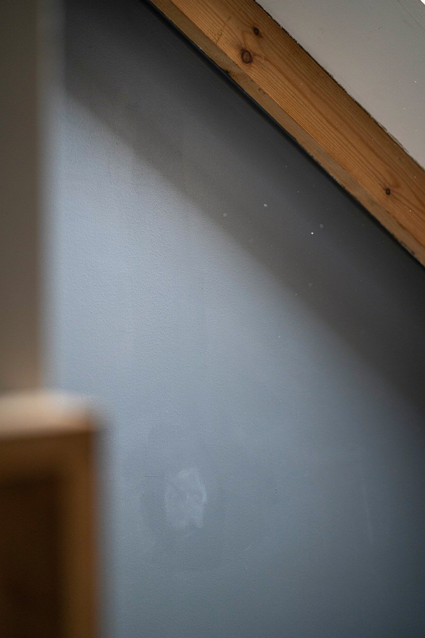 Charcoal paint carried across the wall and up the sloped ceiling