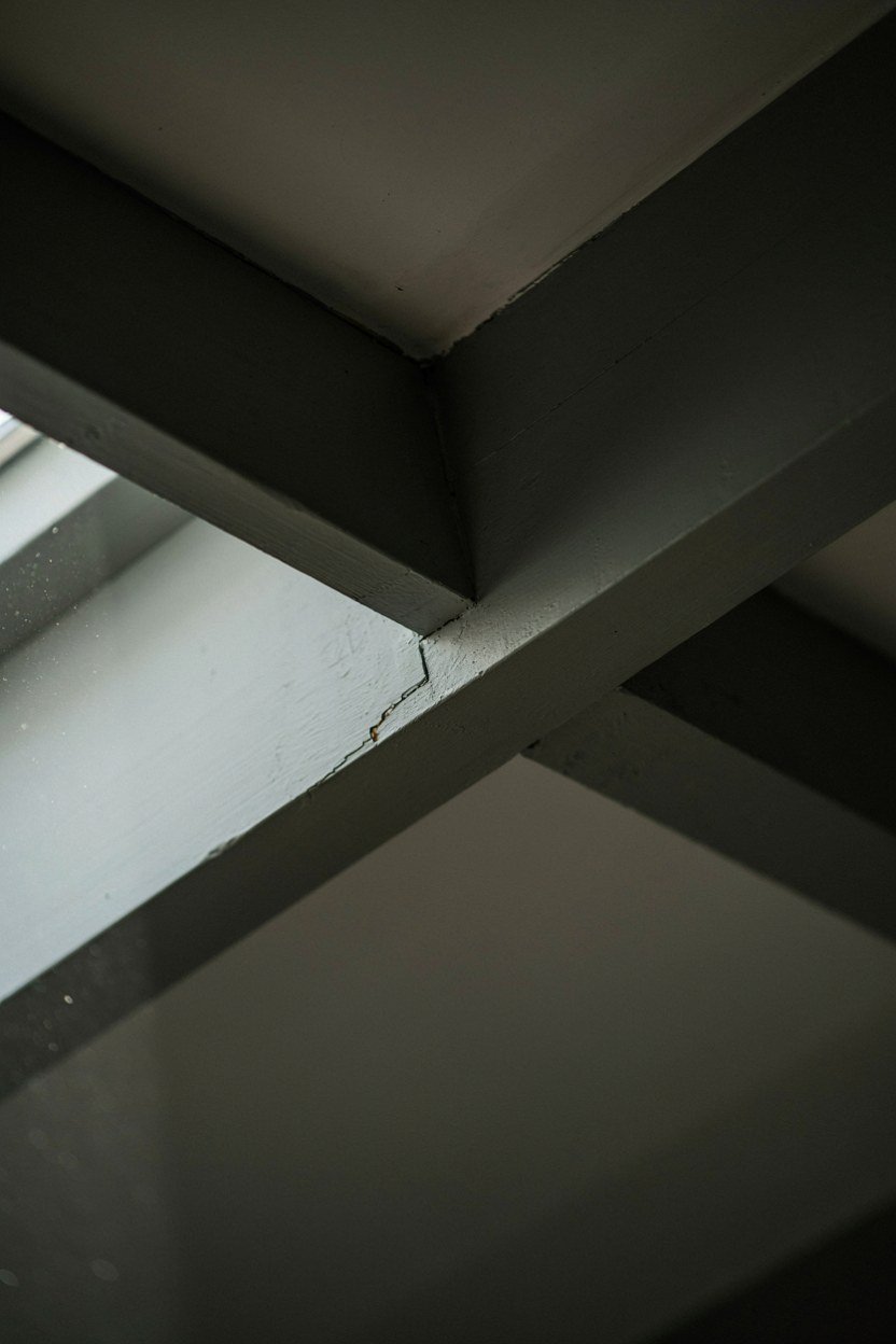 Exposed beams painted the same charcoal as the attic ceiling