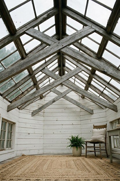 A farmhouse style sunroom addition with exposed wood trusses and shiplap walls
