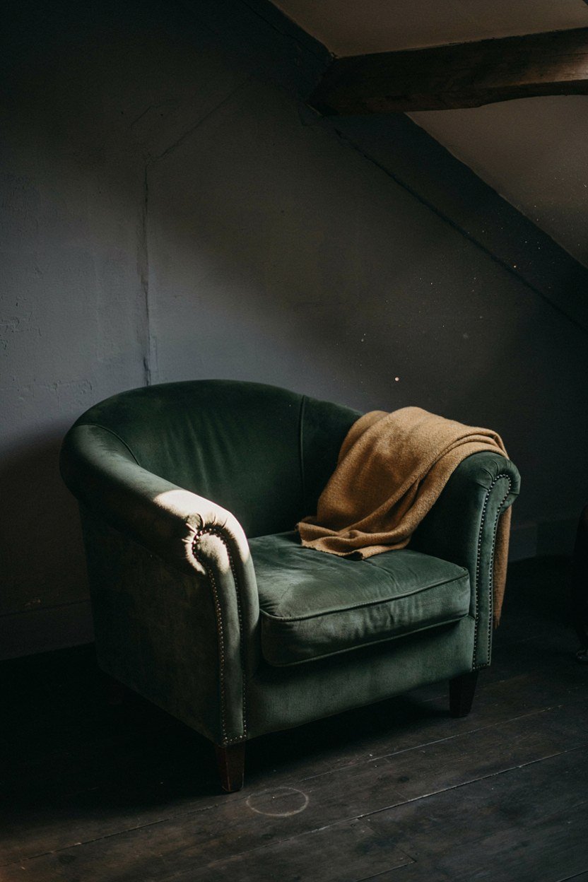 Deep green velvet chair against a charcoal attic wall