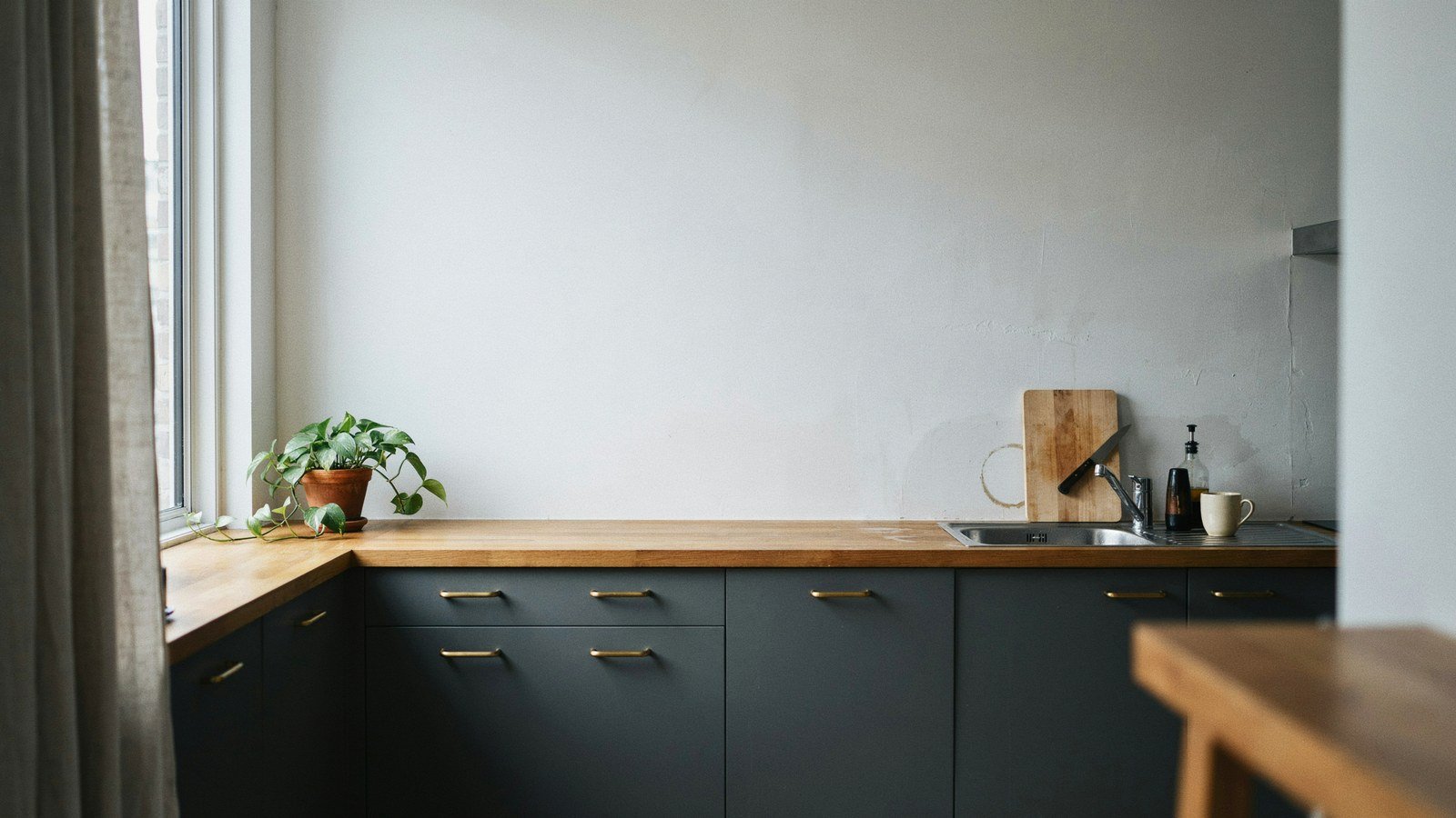 High contrast kitchen with charcoal base units below a chalk white wall