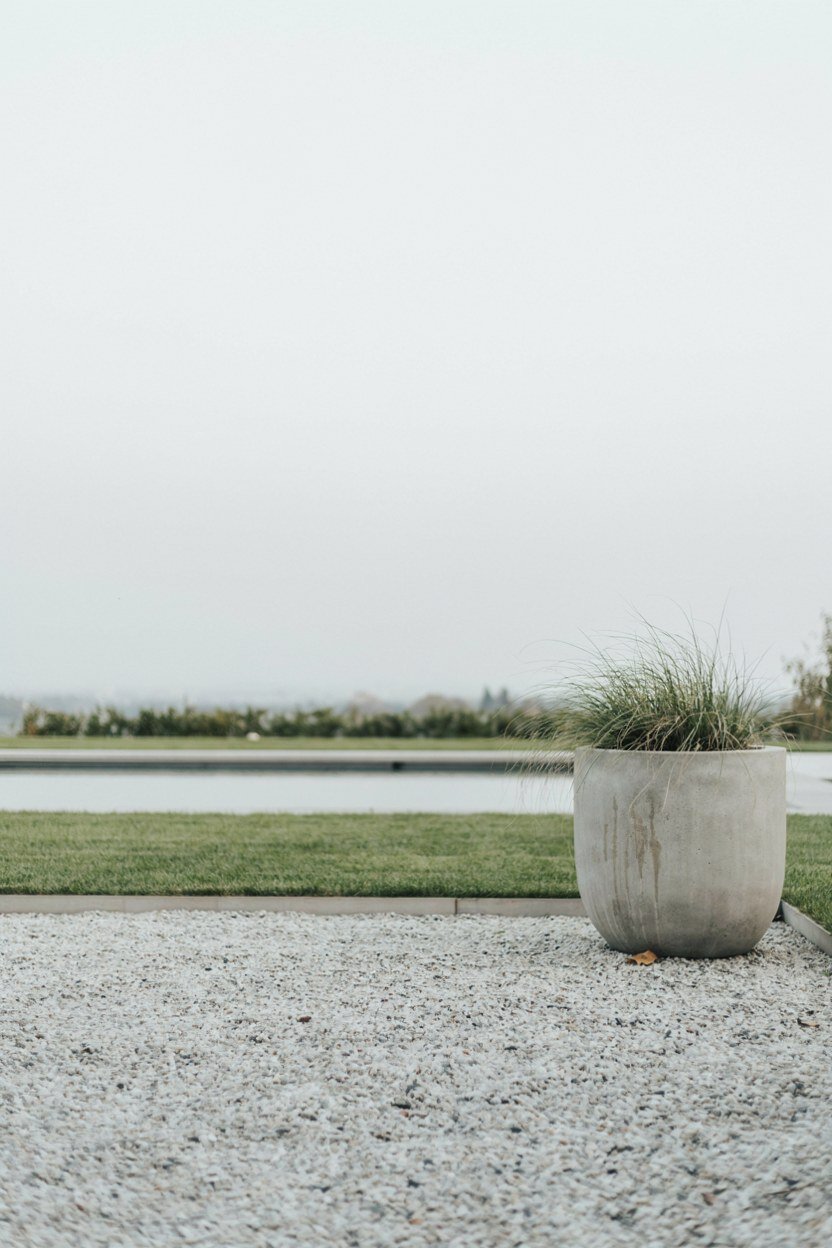 Minimal gravel and clipped lawn surrounding a contemporary pond