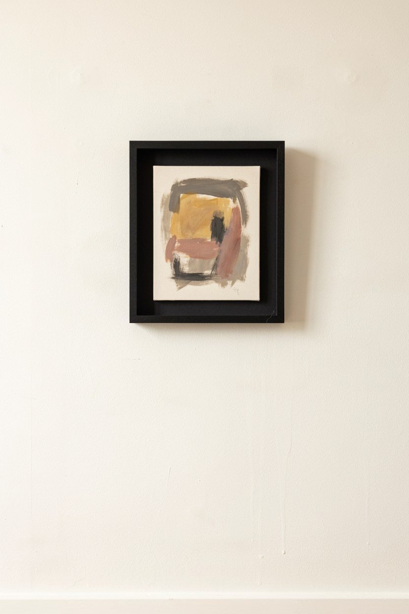 One large black framed artwork on a pale dining room wall