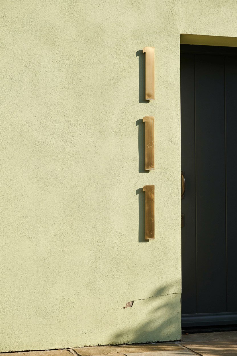 Large brass house numbers mounted beside a front door